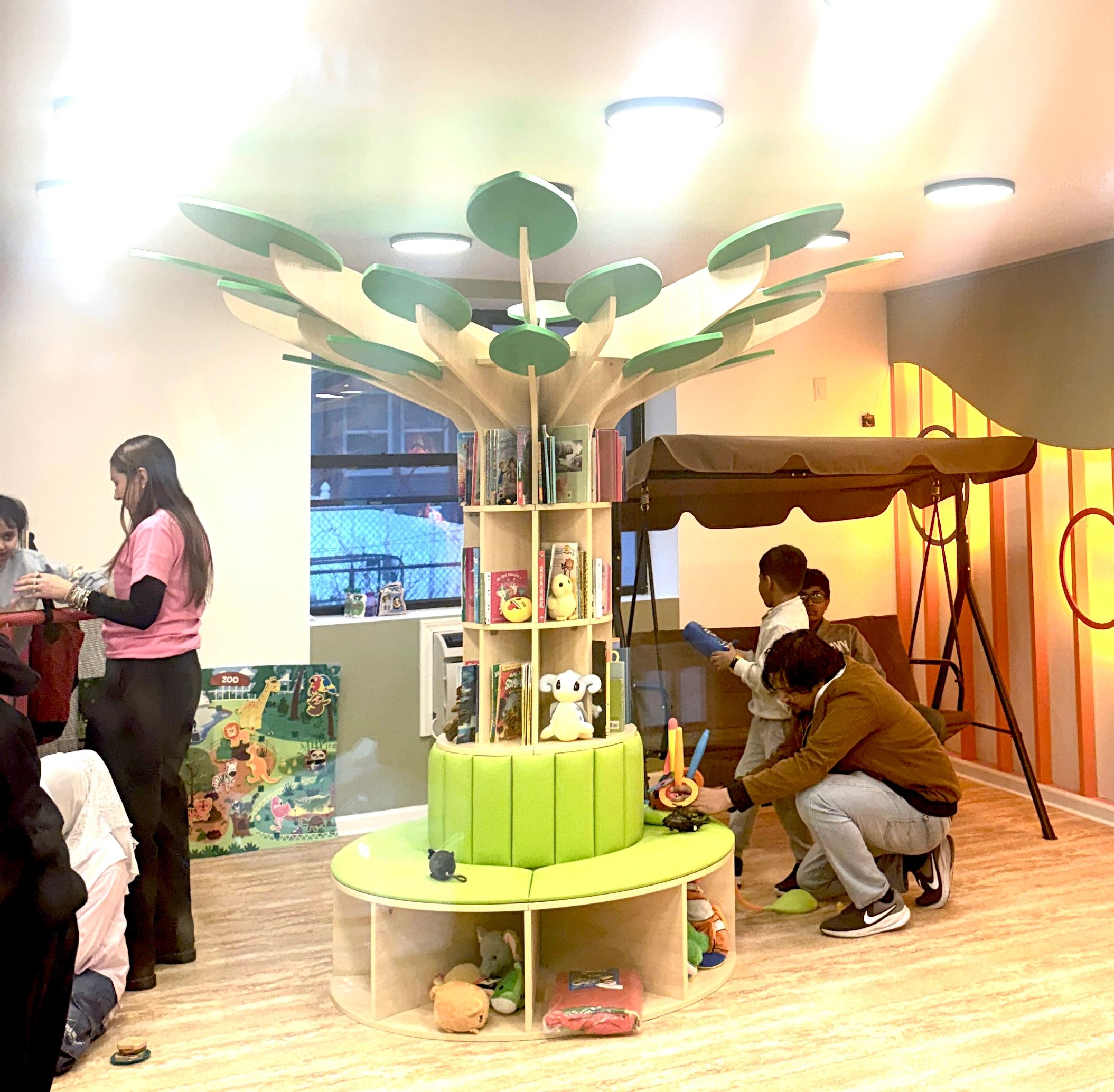 Children’s play and reading area with a tree-shaped bookshelf