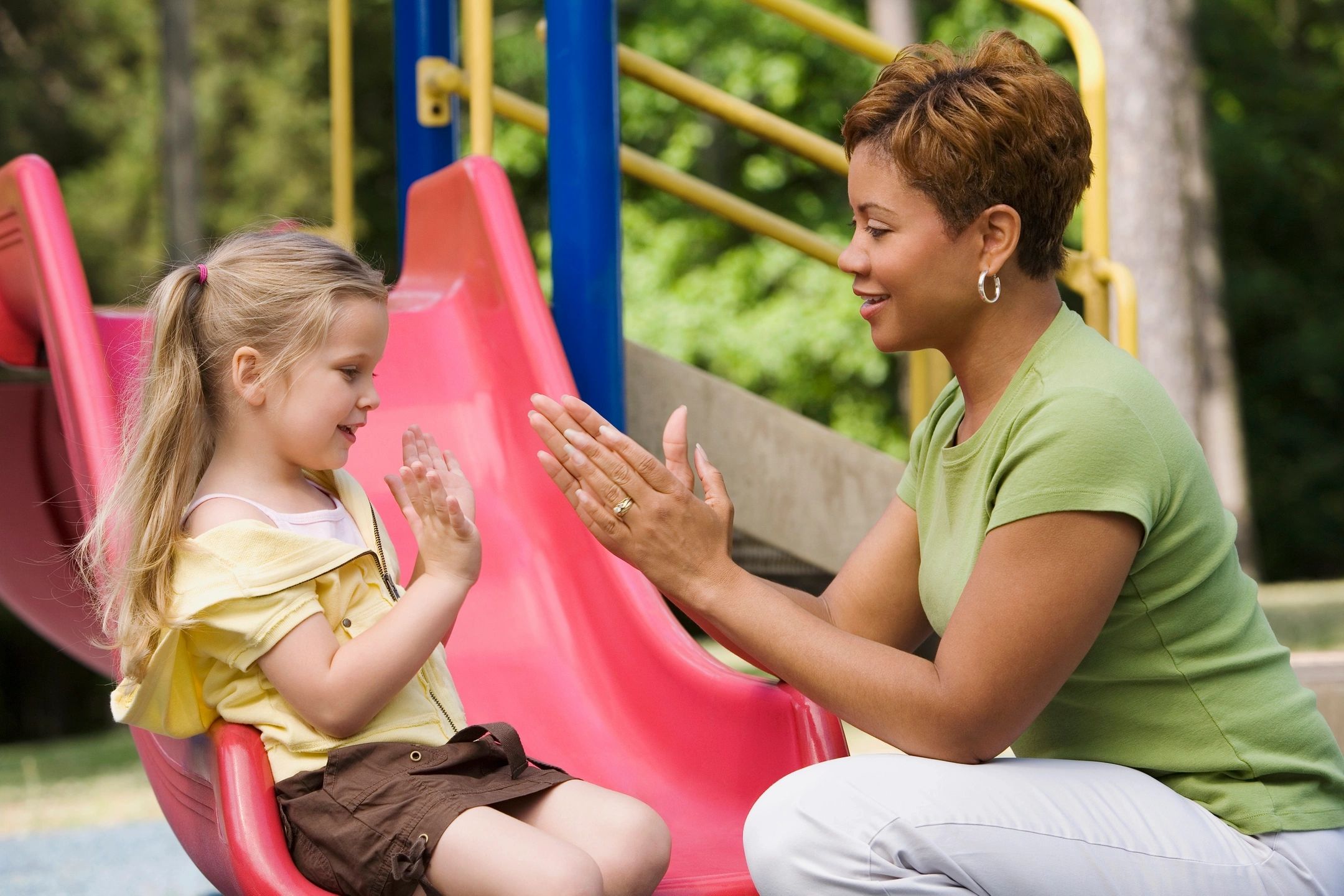Therapist and child sharing a high five at a playground